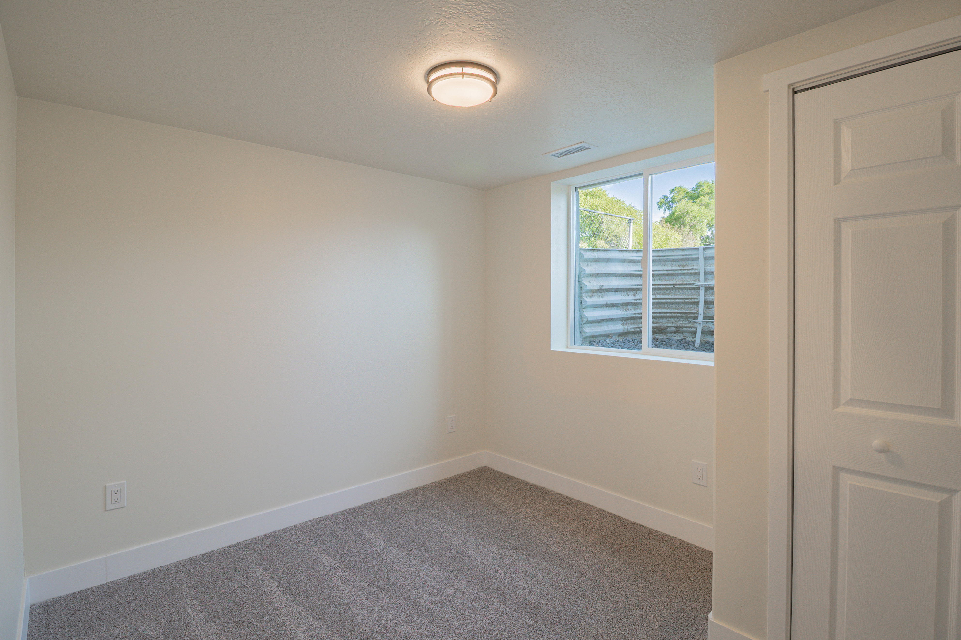 Carpeted empty room featuring baseboards and a textured ceiling