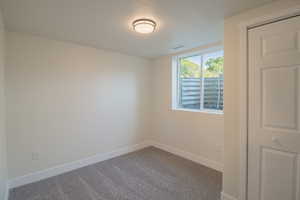 Carpeted empty room featuring baseboards and a textured ceiling