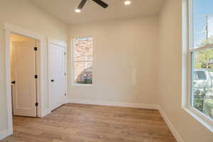 Spare room featuring light wood-type flooring, ceiling fan, and recessed lighting