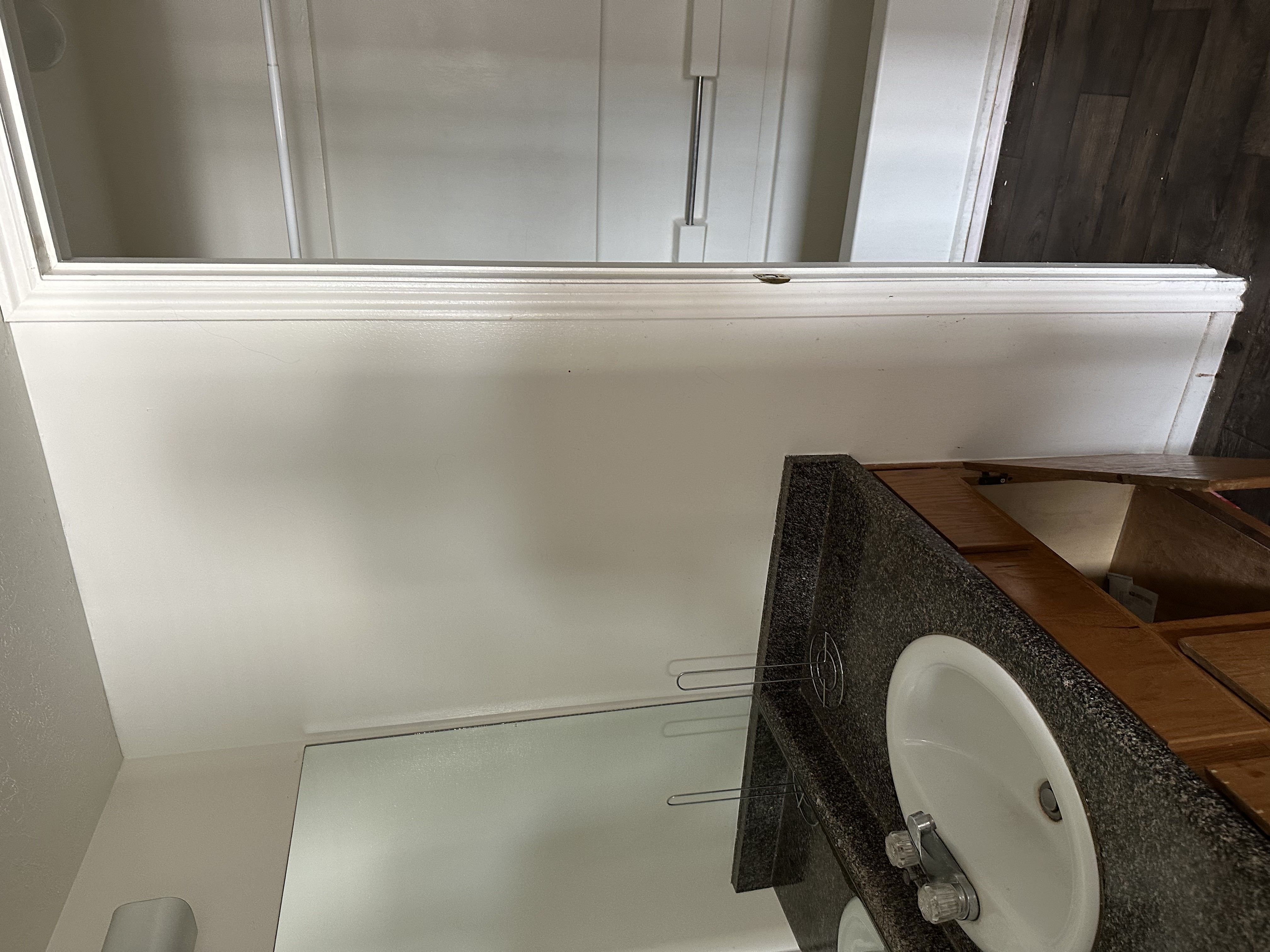 Bathroom with vanity, dark wood-style floors, and a textured ceiling