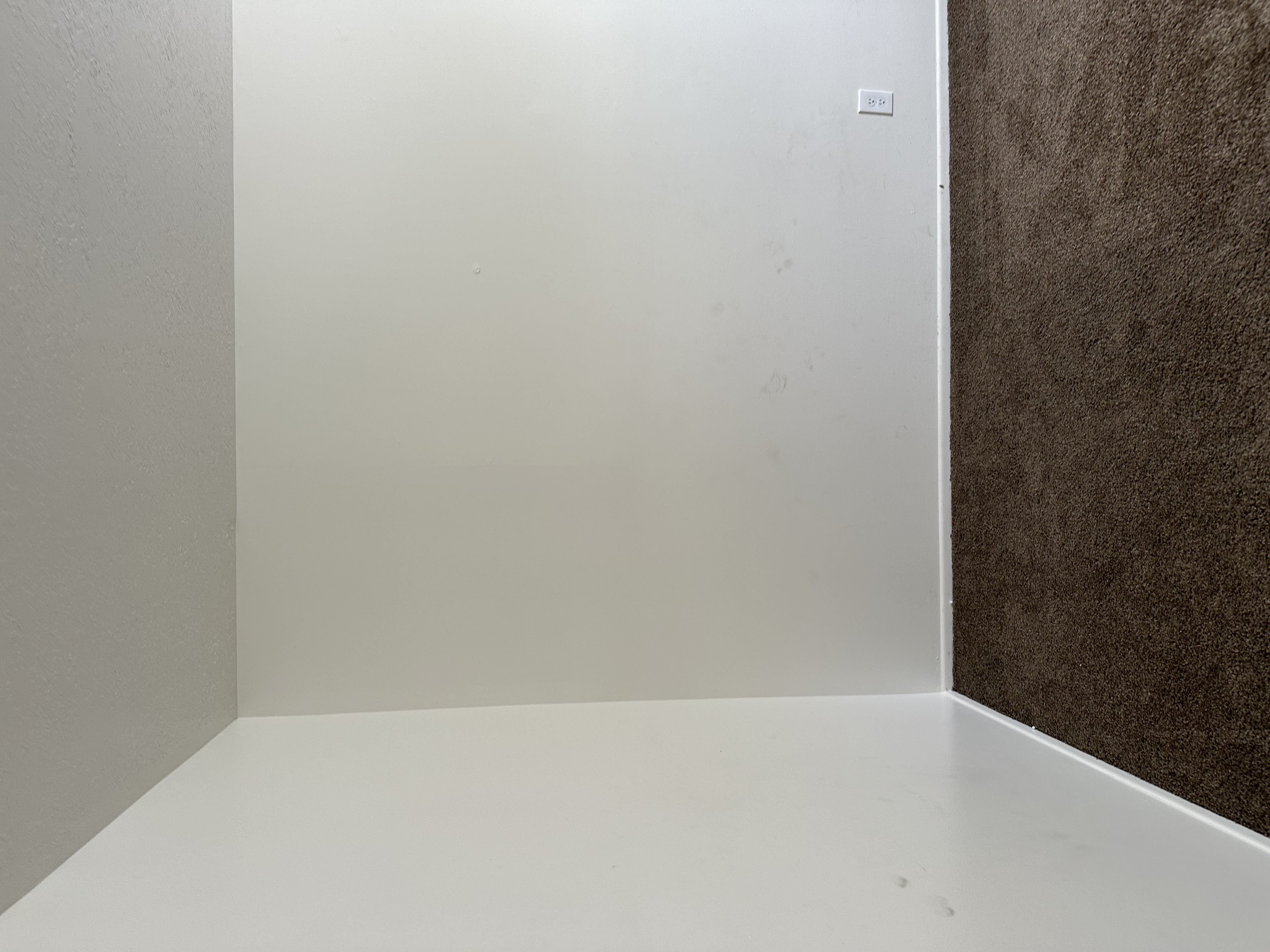 Unfurnished room with dark colored carpet and a textured ceiling