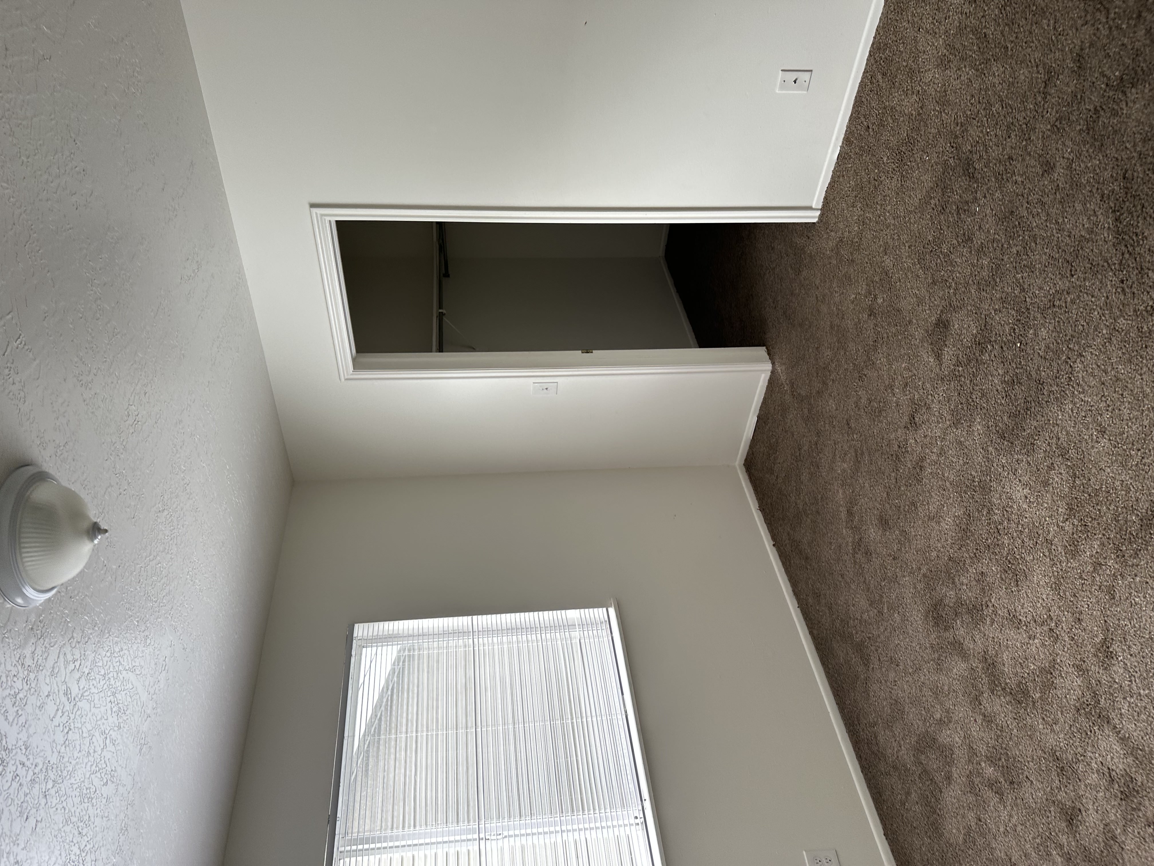 Unfurnished bedroom featuring dark carpet, a textured ceiling, and a walk in closet