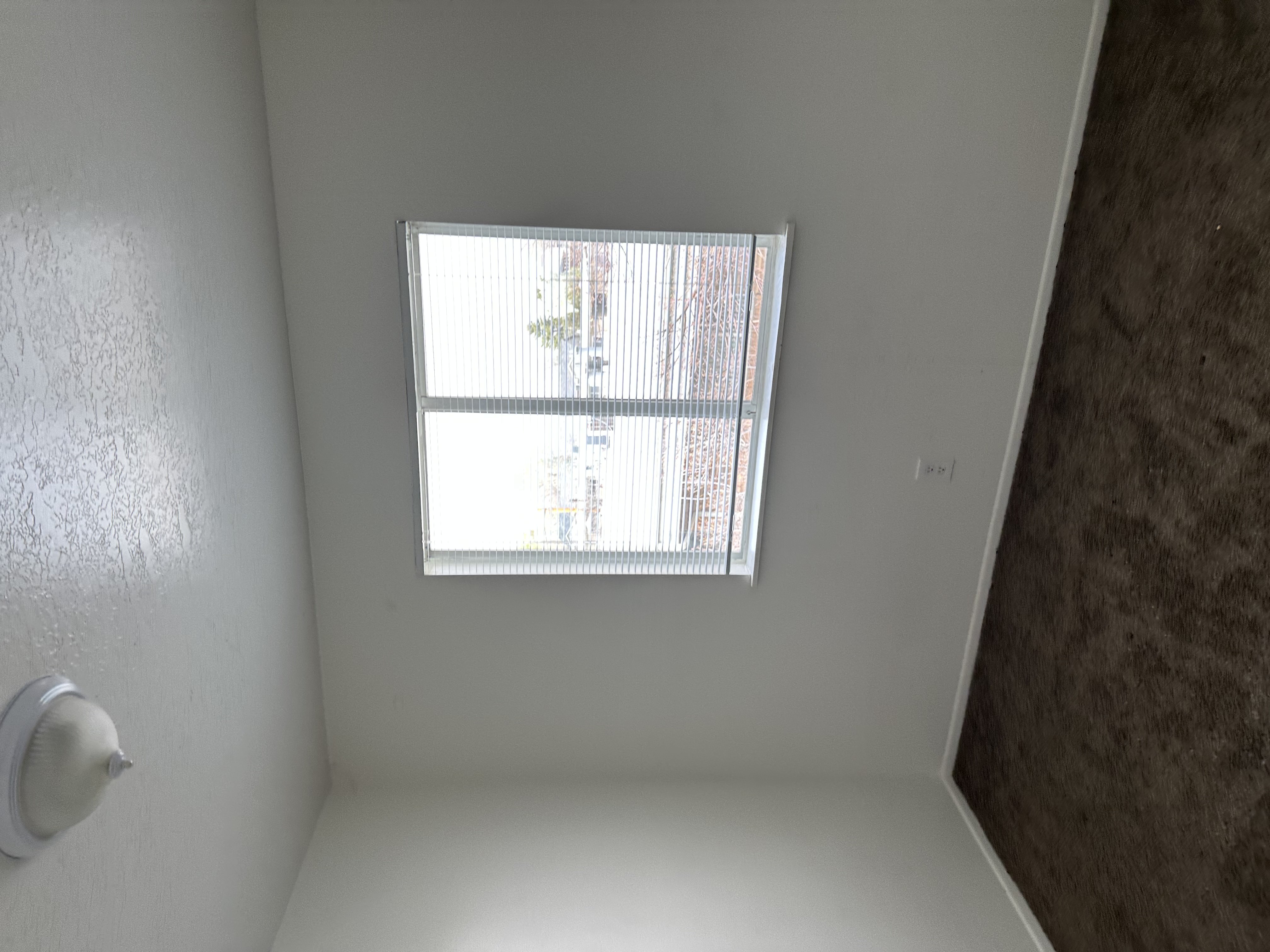 Empty room with dark carpet and a textured ceiling