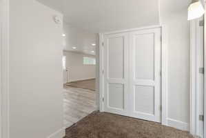 Corridor with light carpet and recessed lighting