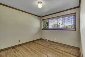 Empty room with light wood finished floors and ornamental molding
