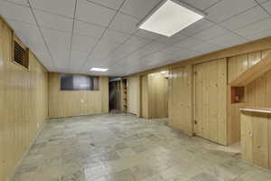 Finished basement featuring wood walls