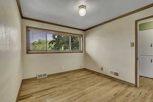 Empty room with light wood-style floors and ornamental molding