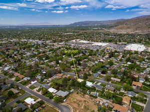 Aerial view of residential area featuring a mountainous background and property parcel outlined