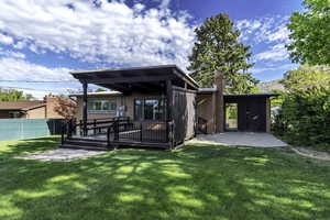 Rear view of property featuring a deck, a chimney, and brick siding