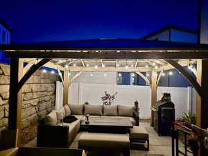 Patio at night featuring outdoor lounge area, a fenced backyard, and a patio area
