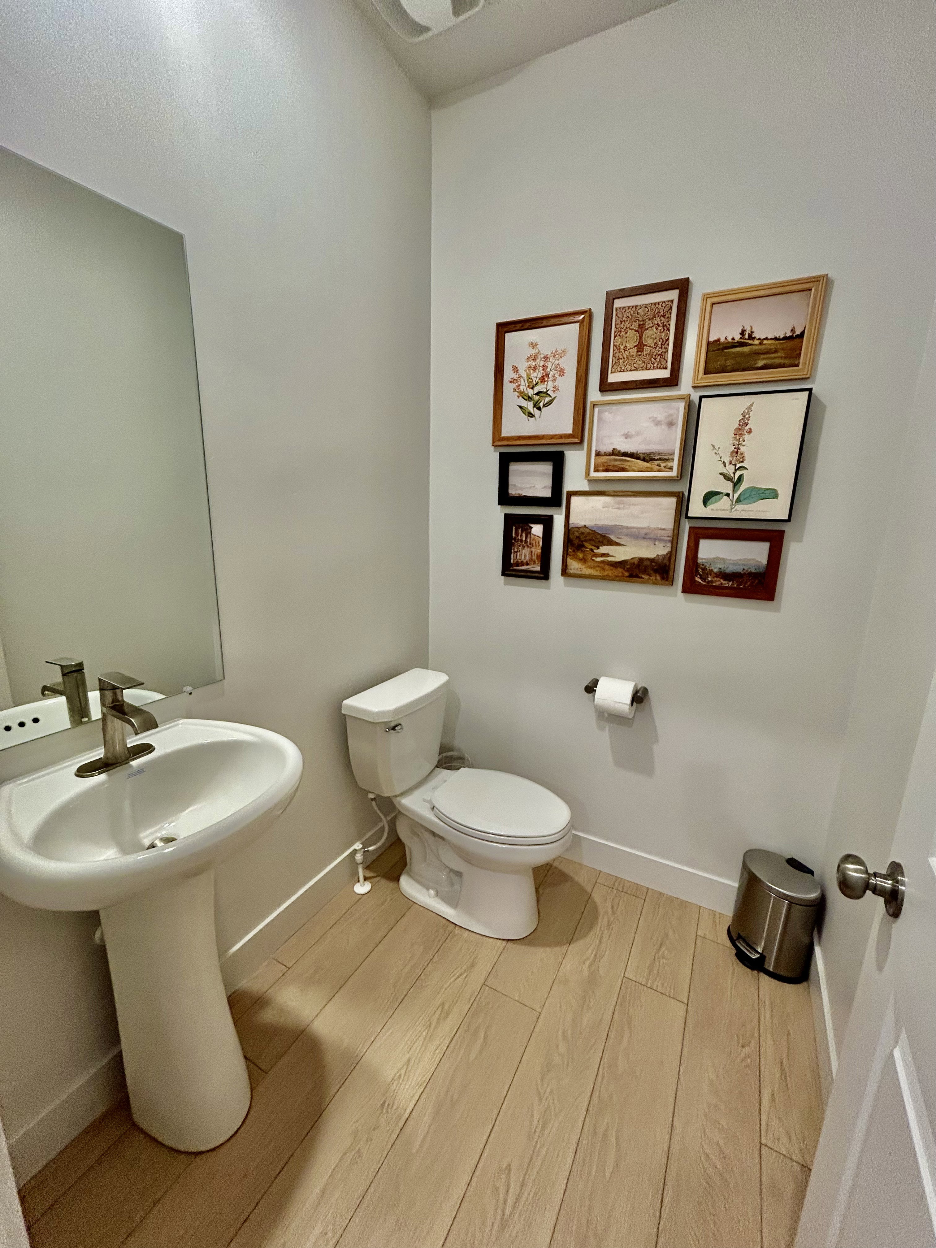 Half bathroom with light wood-style flooring and toilet
