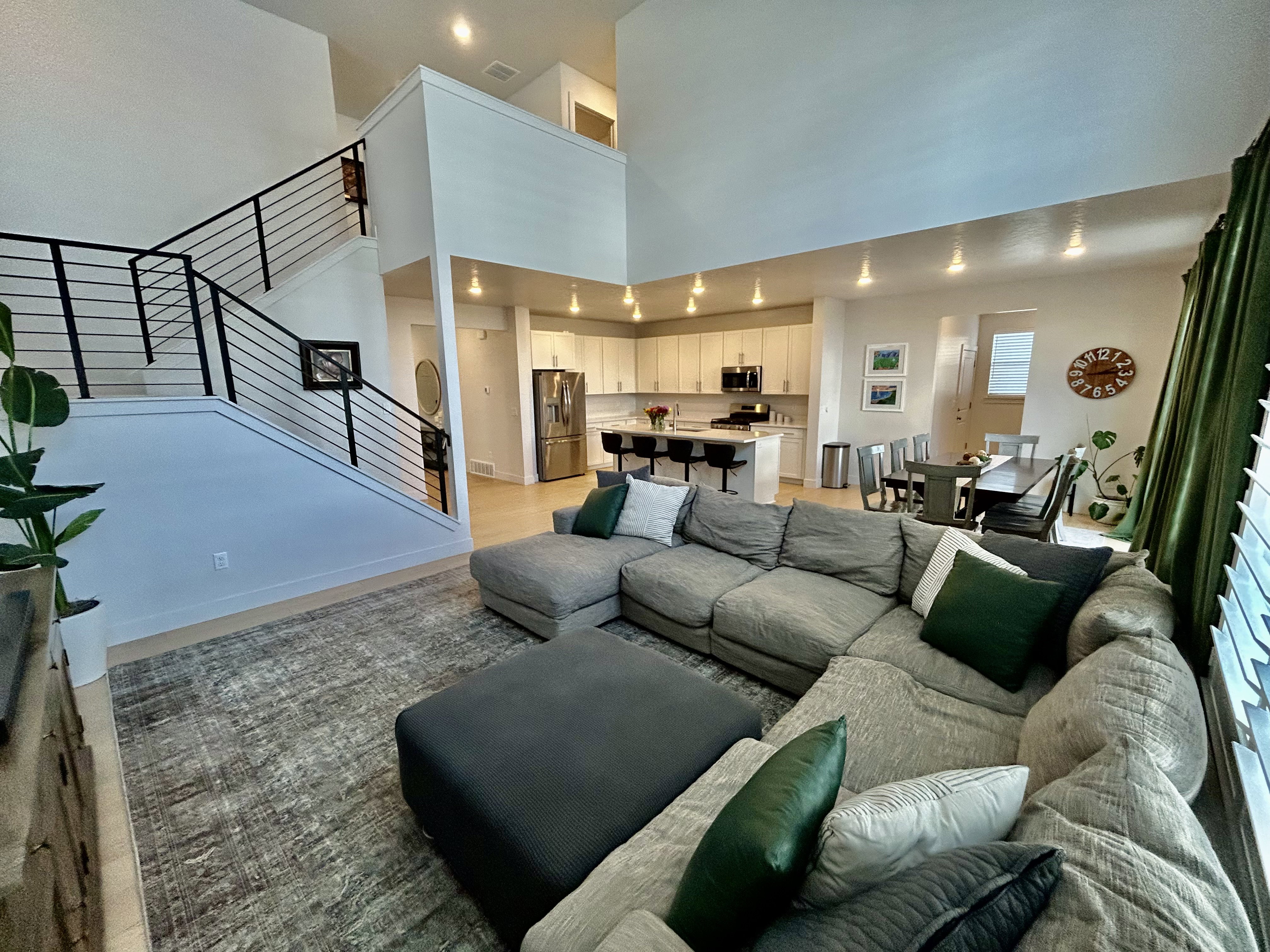 Living area with recessed lighting, light wood-style floors, and a high ceiling