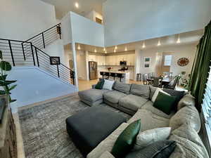 Living area with recessed lighting, light wood-style floors, and a high ceiling
