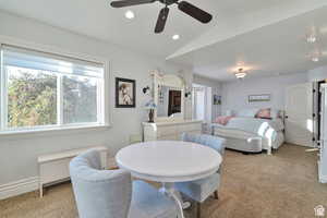 Dining room with lofted ceiling, a ceiling fan, recessed lighting, light colored carpet, and plenty of natural light