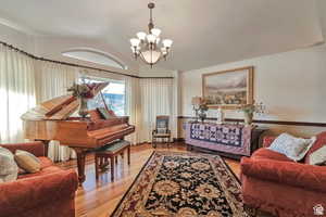 Sitting room featuring light wood finished floors, suspended lighting, and vaulted ceiling
