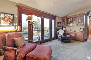 Sitting room with lofted ceiling, french doors, light carpet, wainscoting, and recessed lighting