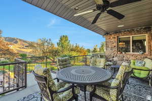 Balcony with outdoor dining area and ceiling fan