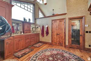 Full bath with light wood-type flooring, ceiling fan, double vanity, and vaulted ceiling