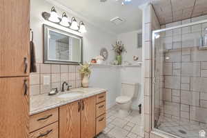 Full bath featuring vanity, a stall shower, crown molding, light tile patterned floors, and tasteful backsplash