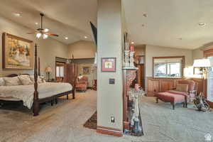 Bedroom featuring light colored carpet, lofted ceiling, recessed lighting, and wainscoting