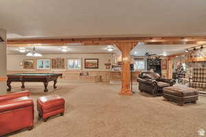 Rec room with carpet flooring, wainscoting, billiards table, ceiling fan, and a textured ceiling