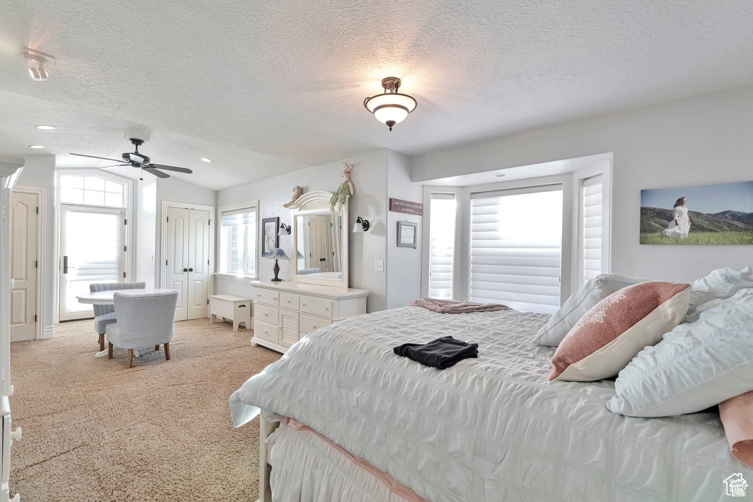 Bedroom with light colored carpet and a ceiling fan