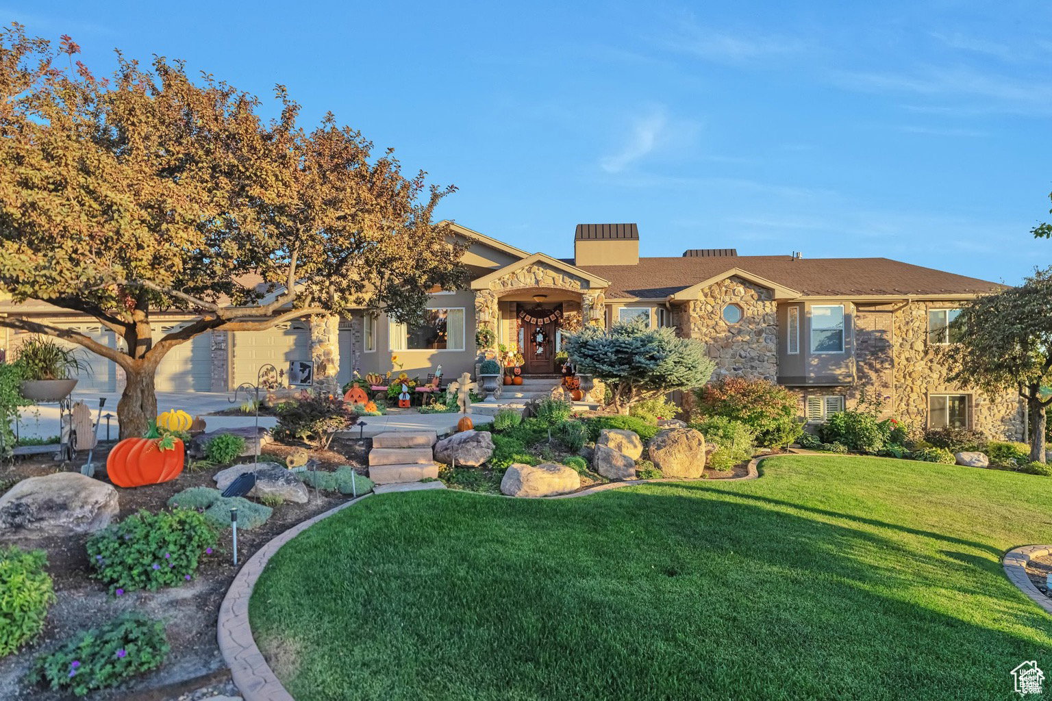 View of front of property featuring a front lawn, a chimney, and stone siding