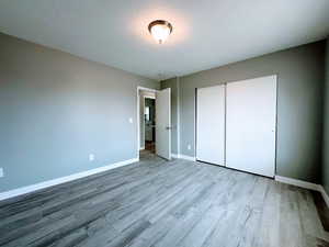 Unfurnished bedroom featuring a closet and light wood finished floors