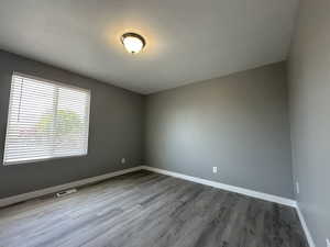 Spare room with a textured ceiling and light wood-style flooring