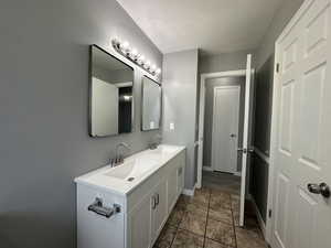 Bathroom with double vanity and a textured ceiling