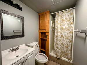 Full bath featuring a shower stall, vanity, tile patterned floors, and a paneled ceiling