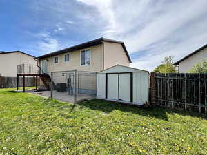 Rear view of house featuring a patio, a shed, and a fenced backyard
