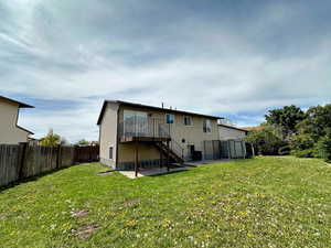 Back of house featuring a patio area, a deck, and a fenced backyard