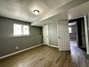 Unfurnished bedroom featuring a textured ceiling and dark wood-style floors