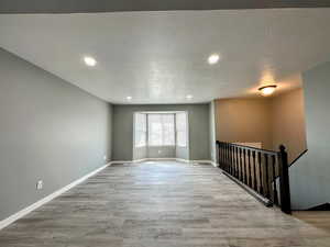 Unfurnished room featuring recessed lighting, light wood-style floors, and a textured ceiling