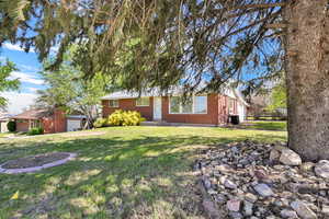 View of front of property featuring a front lawn and brick siding