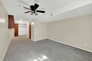 Unfurnished room with ceiling fan, carpet flooring, and a textured ceiling