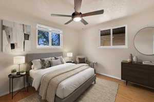 Bedroom featuring light wood-type flooring, a ceiling fan, and a textured ceiling