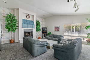 Club House Living area featuring carpet, a fireplace with raised hearth, and lofted ceiling