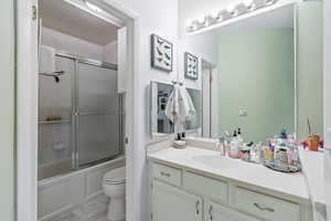 Bathroom featuring vanity and shower / bath combination with glass door