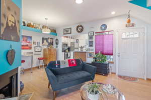 Living room featuring light wood-style flooring and a fireplace with flush hearth