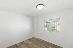 Spare room with dark wood finished floors and baseboards