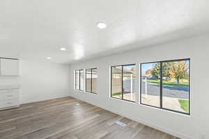 Empty room with light wood-style flooring, recessed lighting, and a textured ceiling