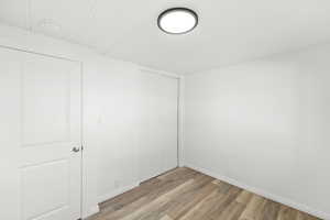 Spare room featuring light wood-type flooring and baseboards