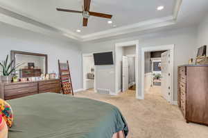 Bedroom featuring a ceiling fan, light colored carpet, ornamental molding, recessed lighting, and a tray ceiling