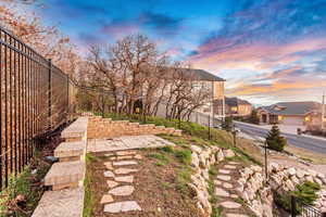 Yard at dusk featuring a fenced backyard, a patio area, and a residential view