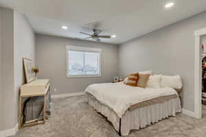Bedroom featuring light colored carpet, ceiling fan, and recessed lighting