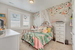 Bedroom featuring light colored carpet and baseboards