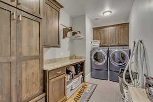 Laundry room featuring cabinet space and washer and clothes dryer