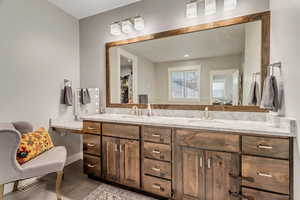 Bathroom featuring double vanity and light wood finished floors